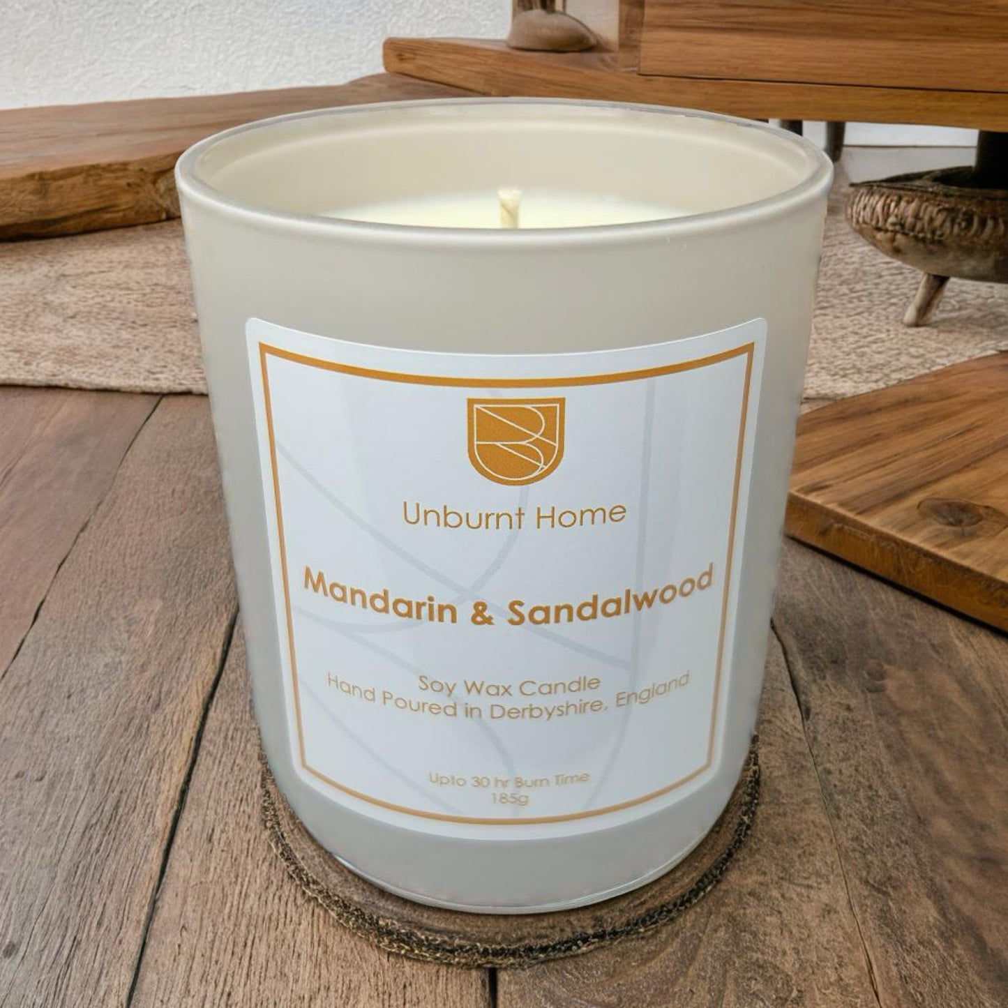Anxiety Candle Mandarin & Sandalwood on wooden surface with furniture in the background
