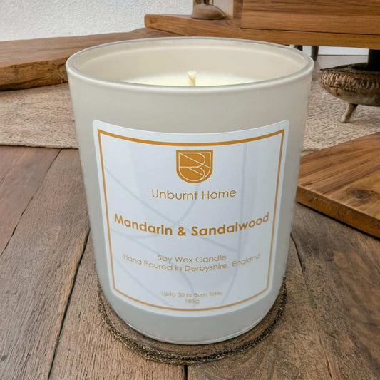 Anxiety Candle Mandarin & Sandalwood on wooden surface with furniture in the background