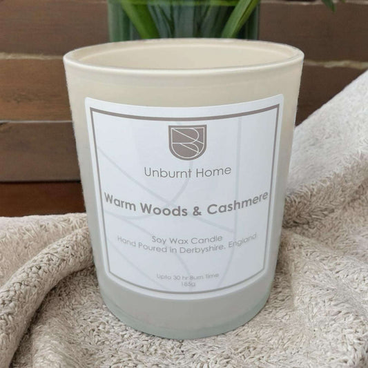 Cashmere candle on cashmere fabric with plants in the background