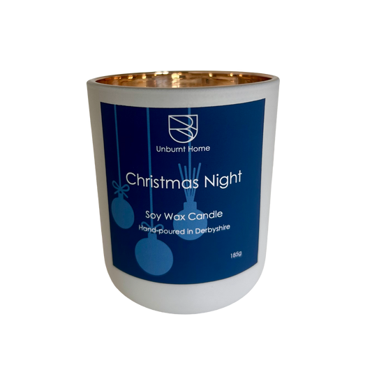 Christmas Night Christmas Candle in a while jar with gold interior with blue label with white text on a white background