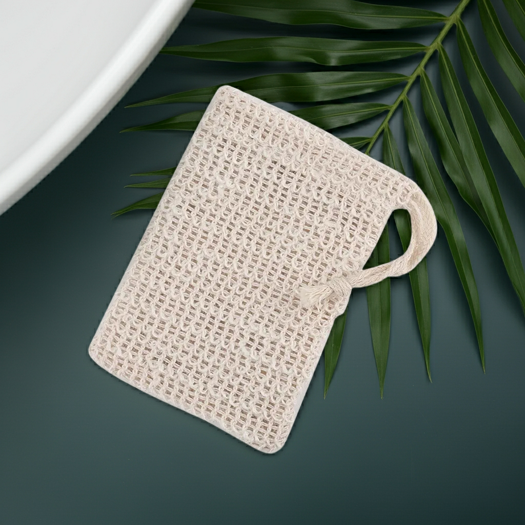 linen soap bag on a dark green bathroom counter top with palm leaf accent and white porcelain sink